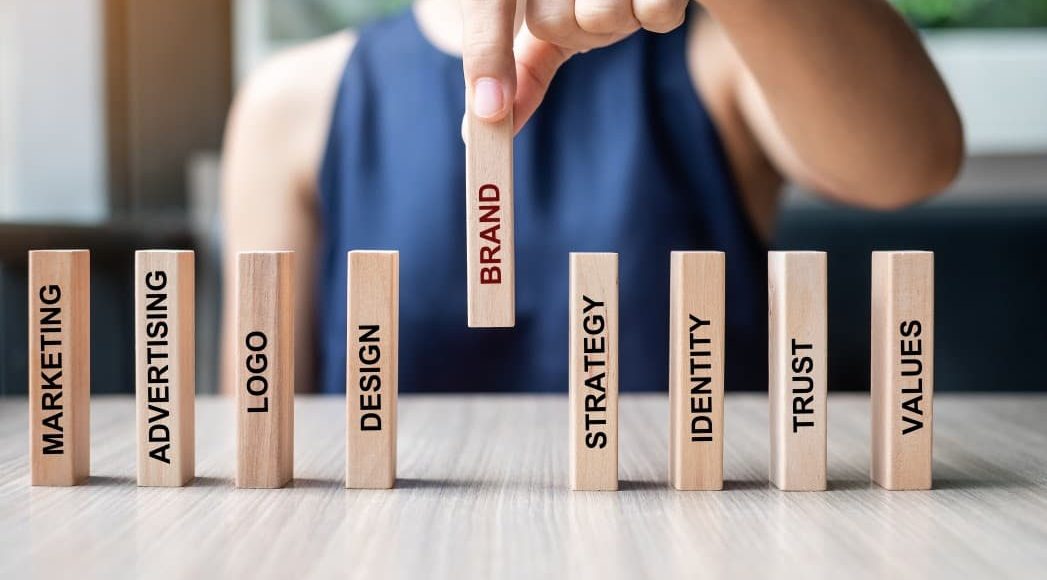 Woman stacking wooden columns with marketing words on them